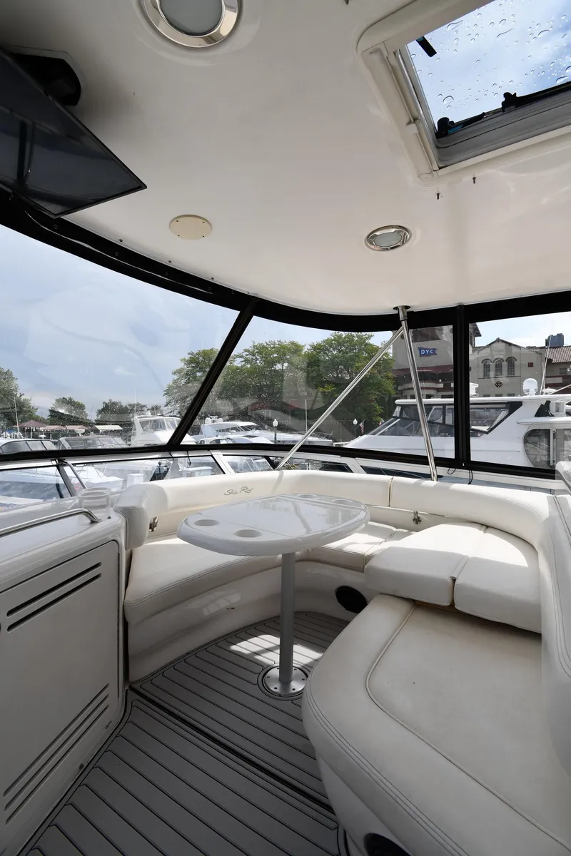 Slide: The Image of 2001 Sea Ray 480 Sedan Bridge interior with white seating and table. - 31