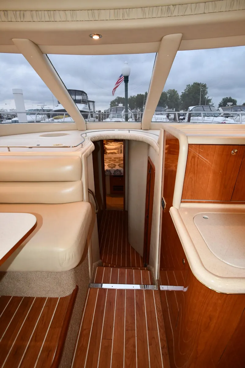 Slide: The Image of Interior view of 2001 Sea Ray 480 Sedan Bridge yacht with wood flooring and seating. - 38