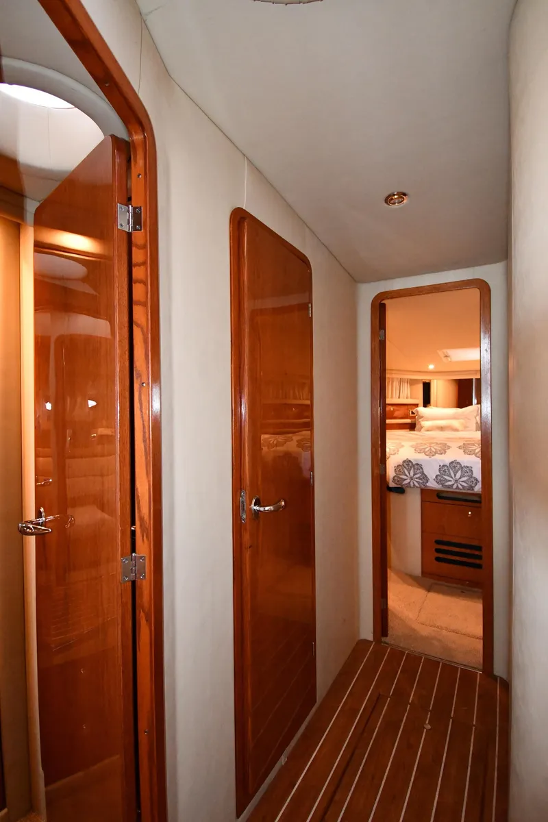 Slide: The Image of Hallway inside 2001 Sea Ray 480 Sedan Bridge yacht with wooden doors and flooring. - 39