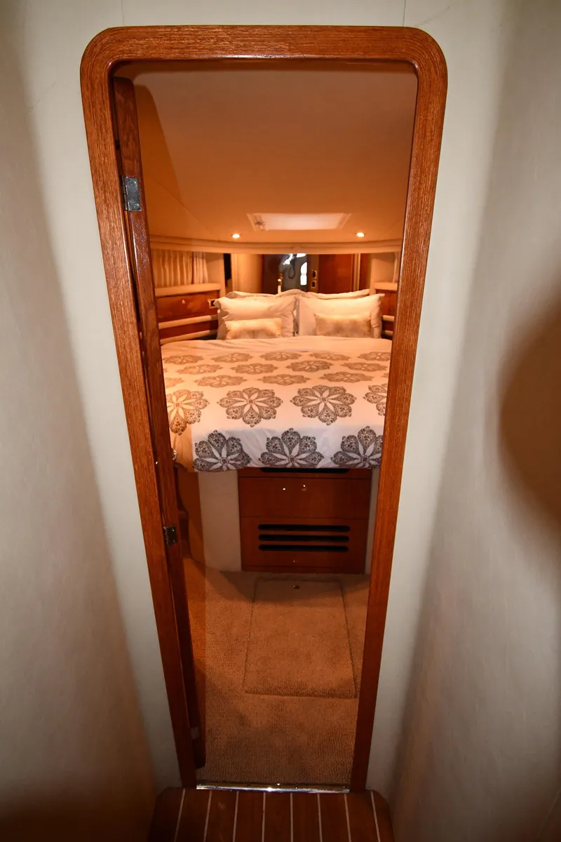 Slide: The Image of 2001 Sea Ray 480 Sedan Bridge cabin interior with cozy bed and wooden accents. - 40