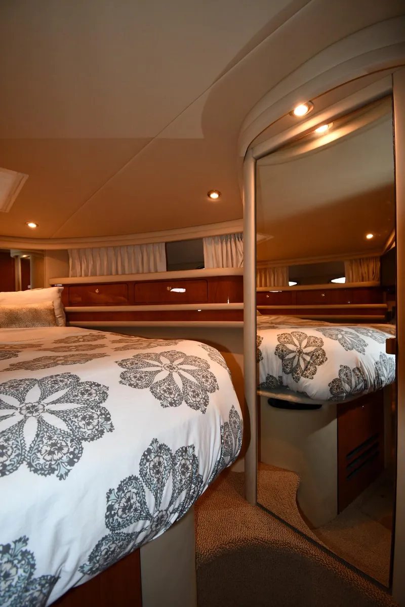 Slide: The Image of Interior of 2001 Sea Ray 480 Sedan Bridge with floral bedding and mirrored closet. - 42