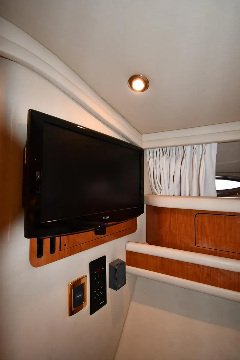 Slide: The Image of Interior of 2001 Sea Ray 480 Sedan Bridge with mounted TV and wood accents. - 46