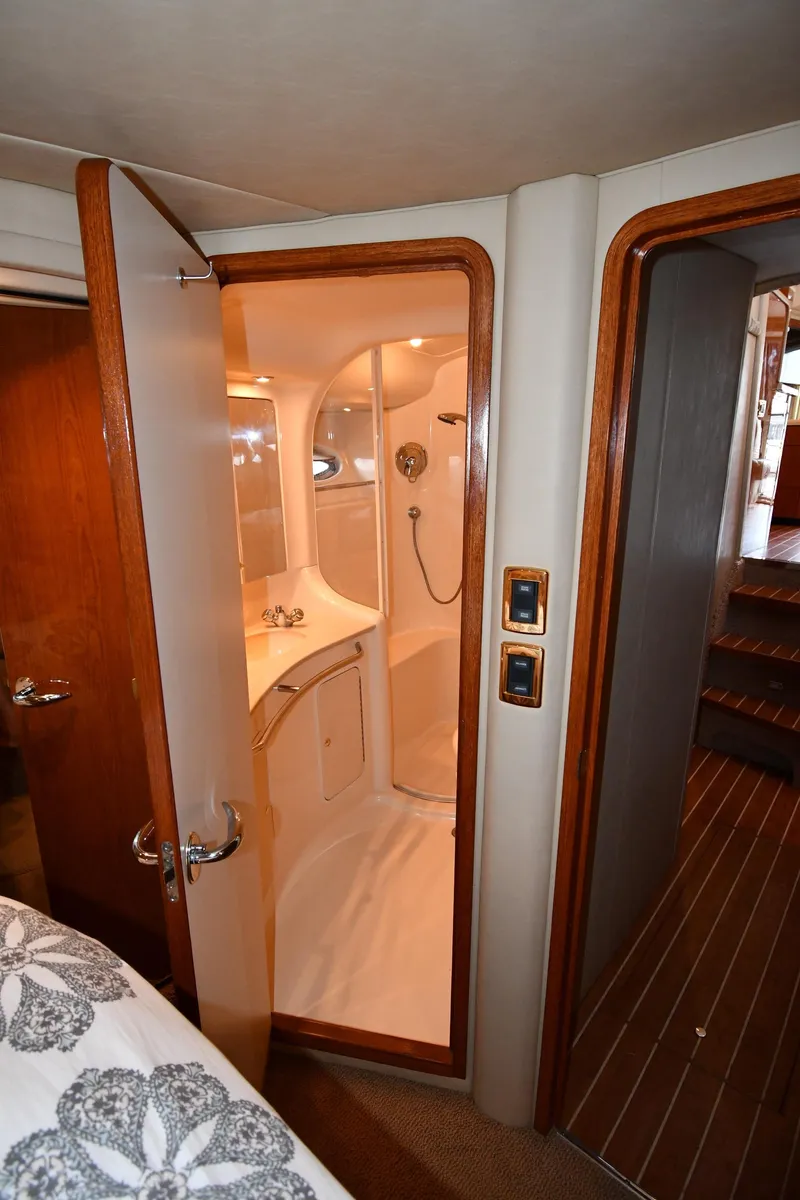 Slide: The Image of 2001 Sea Ray 480 Sedan Bridge yacht bathroom with shower and wooden accents. - 47
