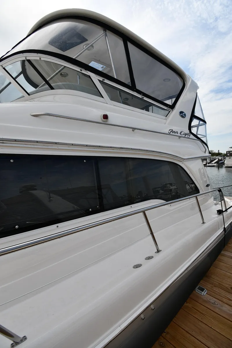 Slide: The Image of 2001 Sea Ray 480 Sedan Bridge yacht docked at marina, side view. - 5