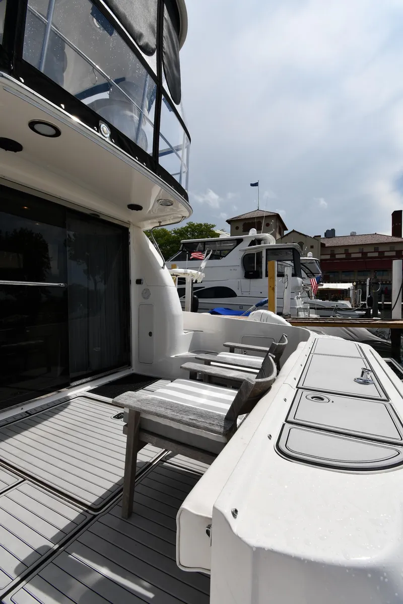 Slide: The Image of 2001 Sea Ray 480 Sedan Bridge yacht docked at marina, showcasing sleek design and spacious deck. - 8