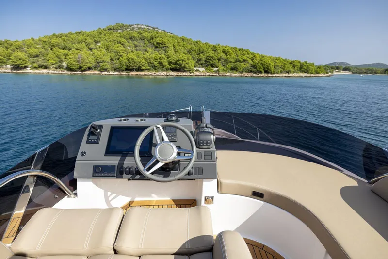 Slide: The Image of Flybridge of 2025 Nimbus 405 yacht with scenic coastal view. - 1