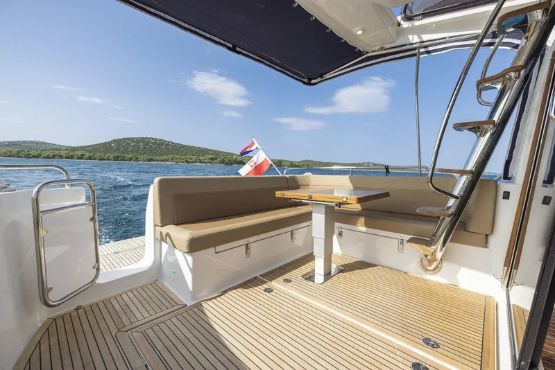 Slide: The Image of Luxurious Nimbus 405 Flybridge yacht deck with seating, table, and scenic ocean view, 2025 model. - 5