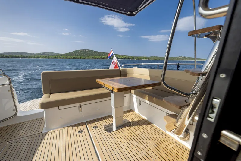 Slide: The Image of Luxurious 2025 Nimbus 405 Flybridge yacht deck with seating and scenic ocean view. - 6