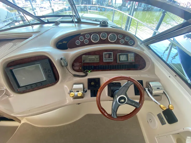 Slide: The Image of 1999 Sea Ray 380 Sundancer helm with wood accents and modern navigation equipment. - 14