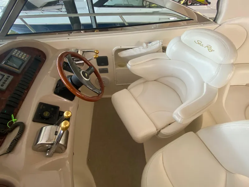 Slide: The Image of 1999 Sea Ray 380 Sundancer helm with white leather seat and wooden steering wheel. - 17