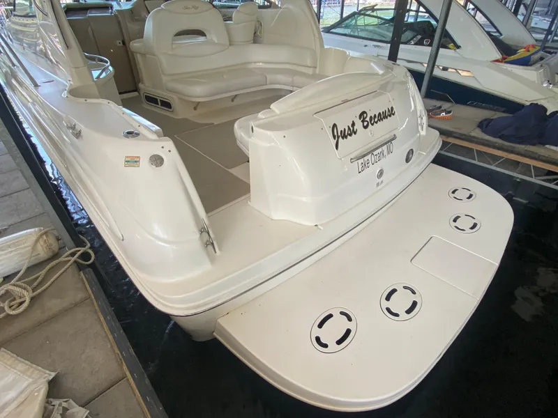 Slide: The Image of 1999 Sea Ray 380 Sundancer boat docked, featuring spacious seating and swim platform. - 18