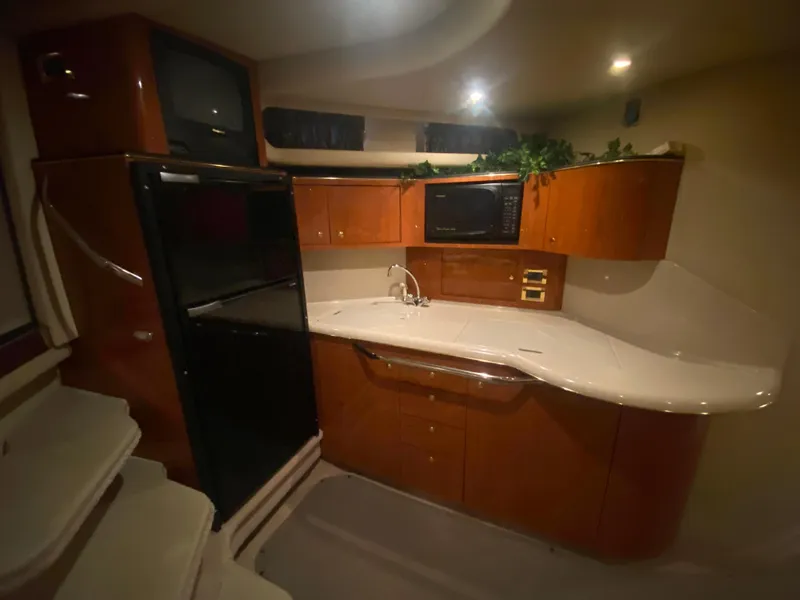 Slide: The Image of 1999 Sea Ray 380 Sundancer interior kitchen with wood cabinets and modern appliances. - 20