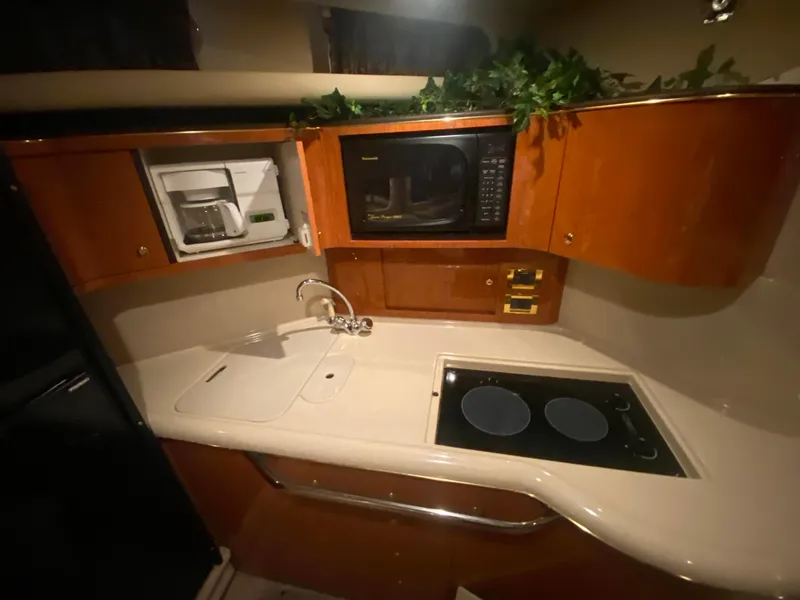 Slide: The Image of 1999 Sea Ray 380 Sundancer kitchen with stove, microwave, and coffee maker. - 21
