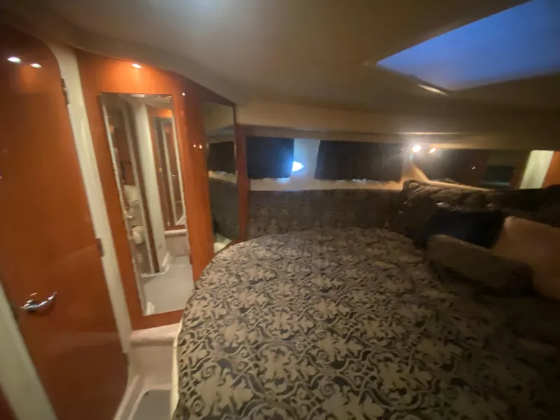 Slide: The Image of Luxurious cabin interior of 1999 Sea Ray 380 Sundancer with patterned bedding and ambient lighting. - 26