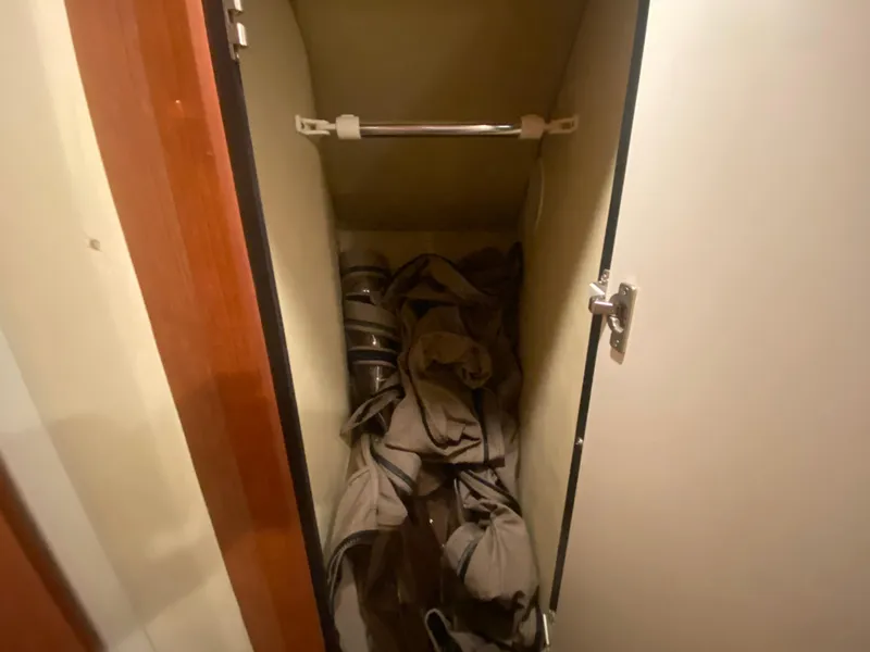 Slide: The Image of Open closet on 1999 Sea Ray 380 Sundancer with stored items inside. - 29