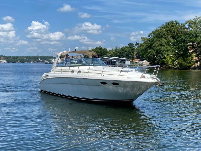 Slide: The Image of 1999 Sea Ray 380 Sundancer cruising on a sunny lake with trees in the background. - 3