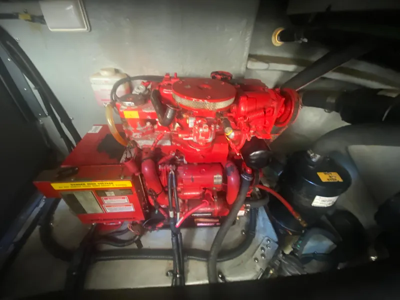 Slide: The Image of Engine compartment of a 1999 Sea Ray 380 Sundancer boat, featuring a red engine. - 38