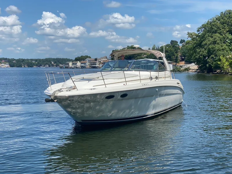 Slide: The Image of 1999 Sea Ray 380 Sundancer yacht cruising on a sunny lake with scenic background. - 4
