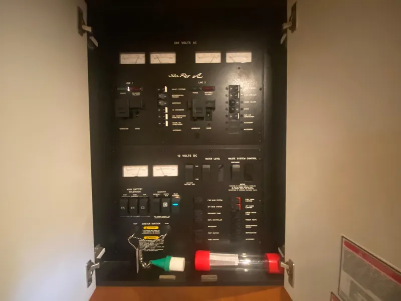 Slide: The Image of Electrical panel inside a 1999 Sea Ray 380 Sundancer boat, featuring various switches and controls. - 43
