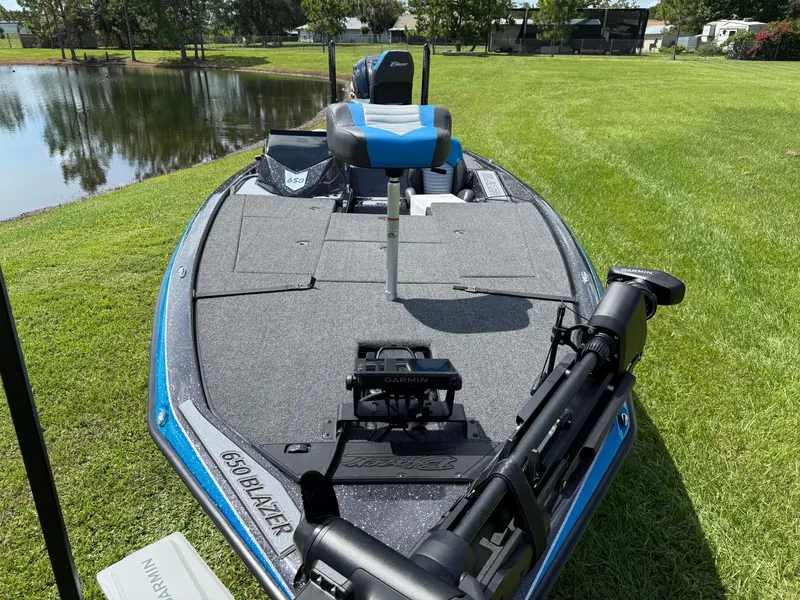 Slide: The Image of 2026 Blazer 650 NAP boat with Garmin equipment, parked on grass by a pond. - 3