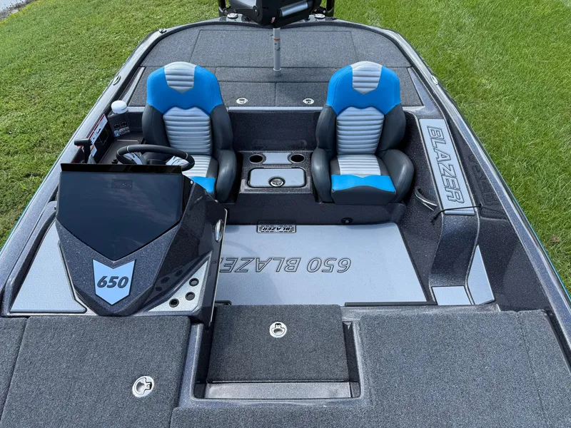 Slide: The Image of 2026 Blazer 650 NAP boat interior with blue and gray seats, steering console, and branding. - 9