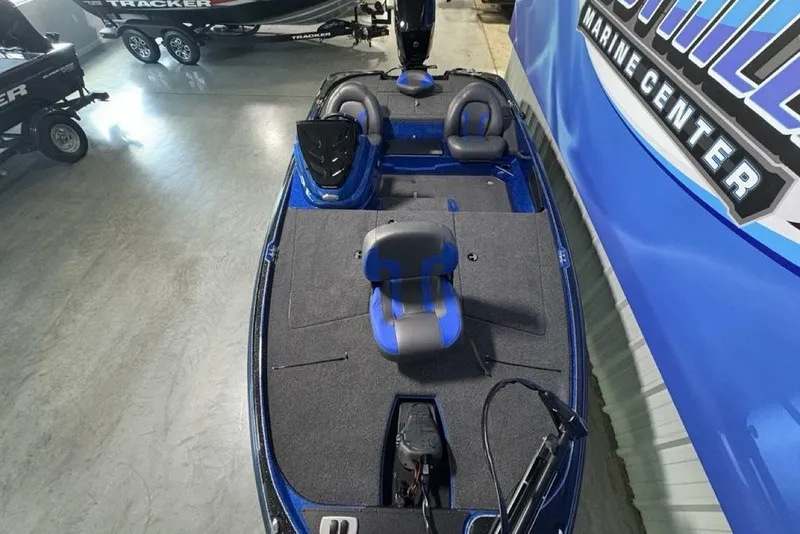 Slide: The Image of 2026 Nitro Z17 boat with blue and gray seating, displayed at a marine center. - 26