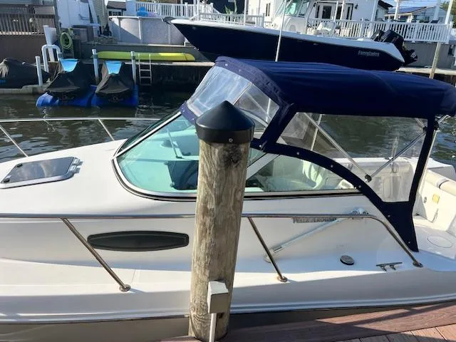 Slide: The Image of 2002 Wellcraft 24 Walkaround boat docked with blue canopy. - 3