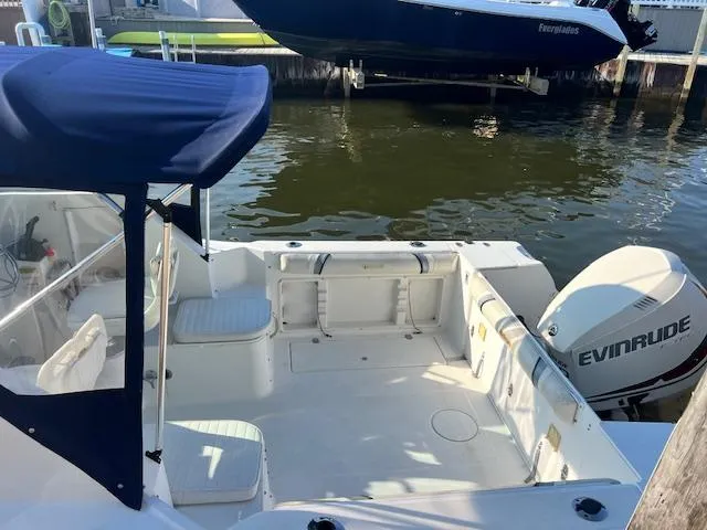 Slide: The Image of 2002 Wellcraft 24 Walkaround boat with Evinrude motor, docked in marina. - 4