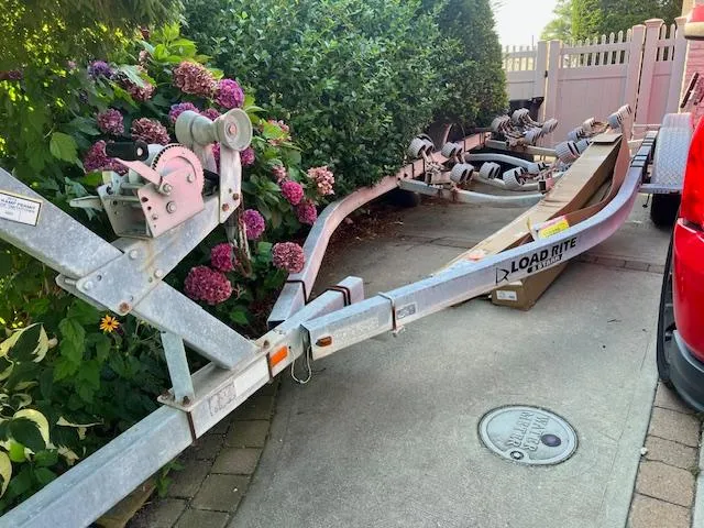 Slide: The Image of Trailer for 2002 Wellcraft 24 Walkaround, surrounded by blooming hydrangeas, parked on driveway. - 6