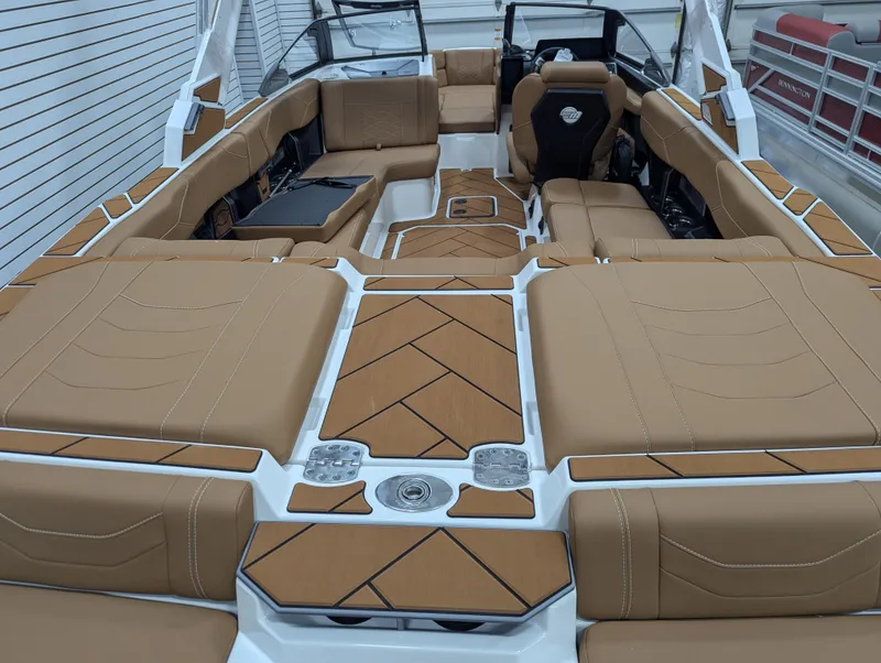 Slide: The Image of 2026 Malibu 23 LSV boat in showroom, featuring sleek design and tan seating. - 10