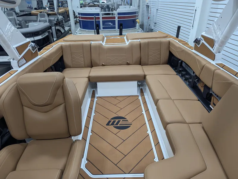 Slide: The Image of 2026 Malibu 23 LSV boat interior with tan seating and built-in speakers. - 19