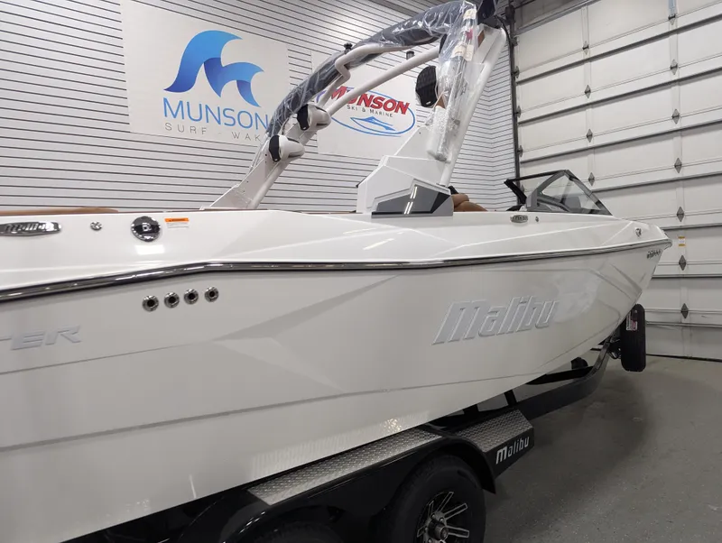 Slide: The Image of 2026 Malibu 23 LSV boat in showroom, white exterior, on trailer. - 4