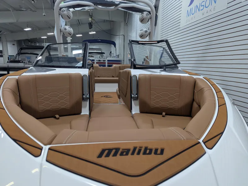 Slide: The Image of 2026 Malibu 23 LSV boat displayed indoors at Munson Ski & Marine showroom. - 7