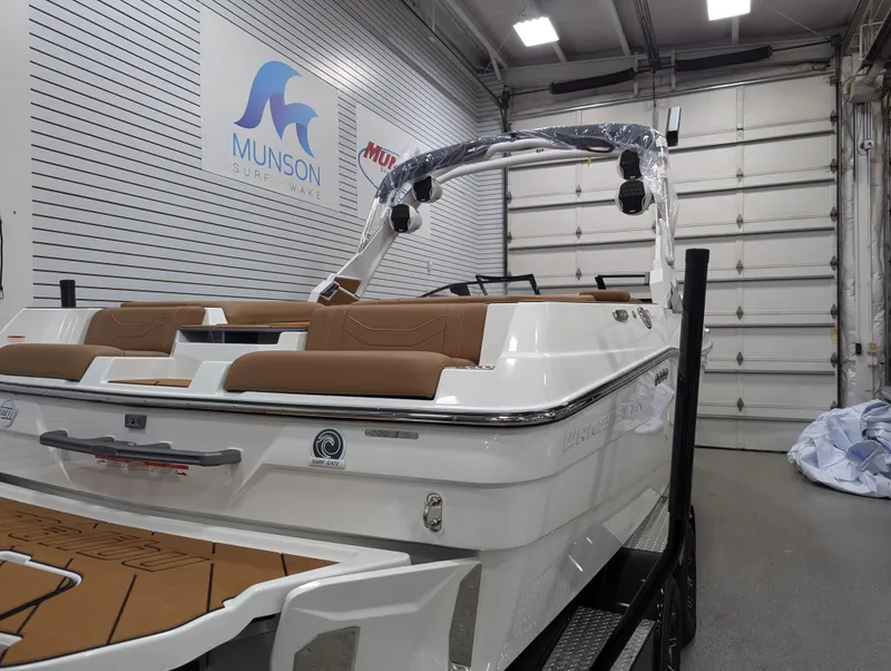 Slide: The Image of 2026 Malibu 23 LSV boat in showroom, featuring sleek design and brown seating. - 9
