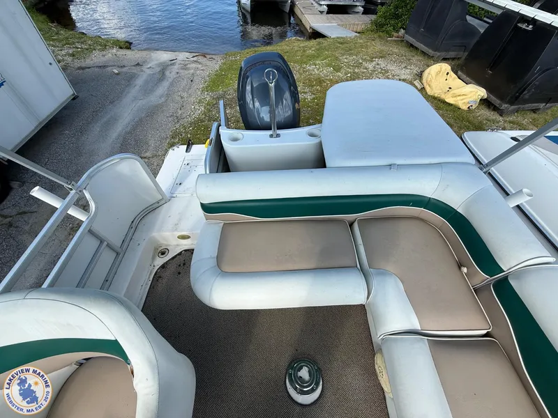 Slide: The Image of 2005 Hurricane FunDeck 226 REF boat interior with seating and helm near water. - 10
