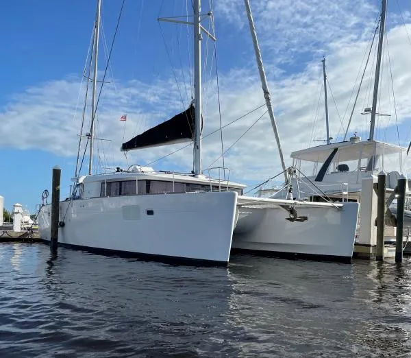 The Image of 2018 Lagoon 450 F catamaran docked at marina under blue sky. - 1