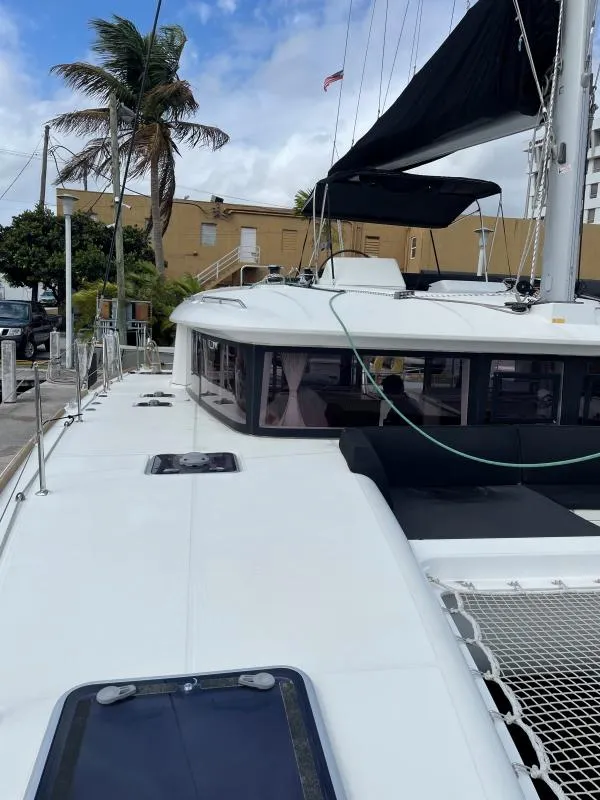 Slide: The Image of 2018 Lagoon 450 F catamaran docked, featuring sleek design and spacious deck. - 13