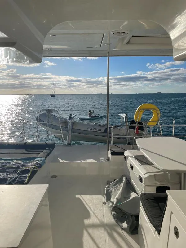 Slide: The Image of Lagoon 450 F catamaran interior with ocean view, featuring a small boat and life preserver. - 14