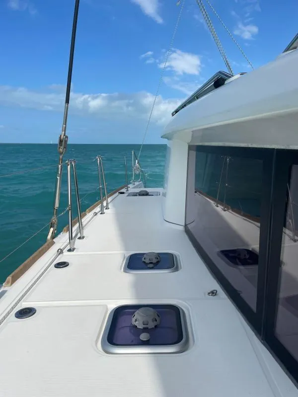Slide: The Image of 2018 Lagoon 450 F catamaran deck with ocean view under clear blue sky. - 18