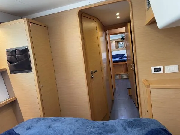 Slide: The Image of Interior of 2018 Lagoon 450 F yacht, featuring cozy cabin with wooden finish and blue bedding. - 6