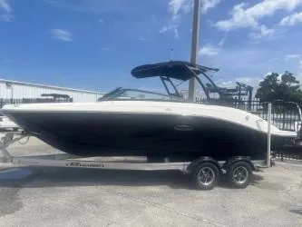The Image of 2024 Sea Ray SPX 230 boat on trailer, parked outdoors under a clear sky. - 0