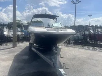 Slide: The Image of 2024 Sea Ray SPX 230 boat on trailer, parked outdoors under a cloudy sky. - 4