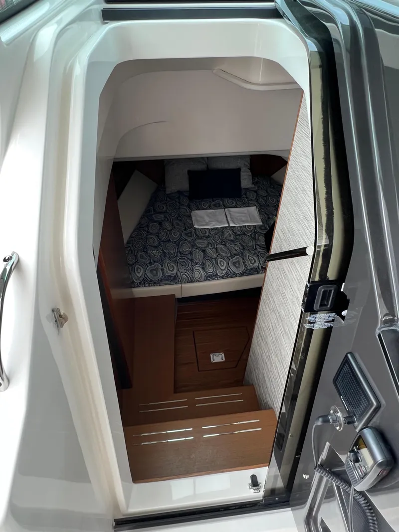 Slide: The Image of 2026 Tiara Yachts 34 LS cabin interior with patterned bedding and wooden flooring. - 13