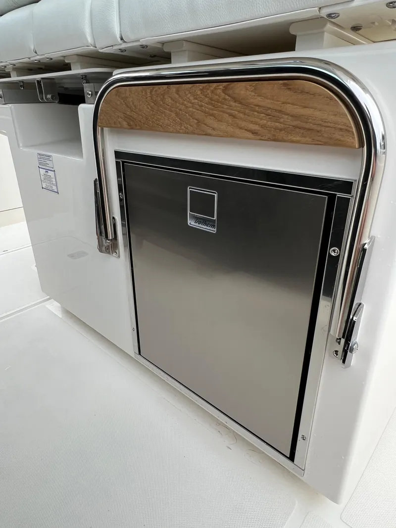 Slide: The Image of 2026 Tiara Yachts 34 LS interior with stainless steel appliance and cushioned seating. - 14