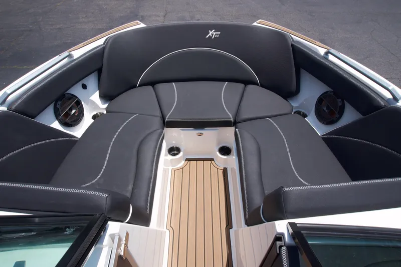 Slide: The Image of 2021 MasterCraft XT22 boat interior with black seating and teak flooring. - 10