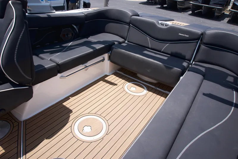 Slide: The Image of 2021 MasterCraft XT22 boat interior with black seating and teak flooring. - 12