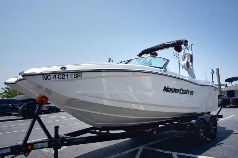 Slide: The Image of 2021 MasterCraft XT22 boat on trailer in parking lot, side view. - 6