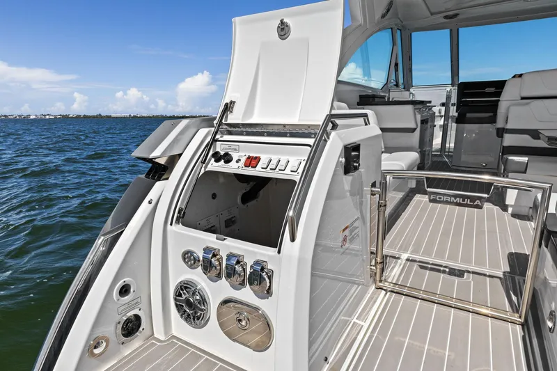 Slide: The Image of 2023 Formula 380 Super Sport Crossover OB boat interior with open hatch and control panel. - 19