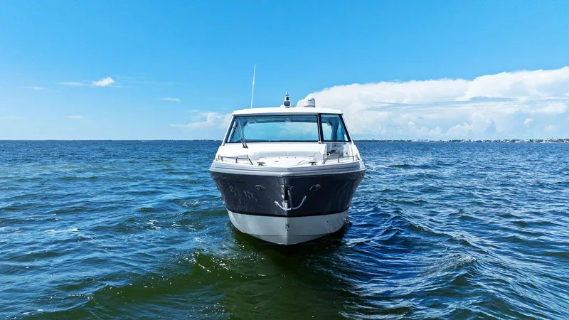 Slide: The Image of 2023 Formula 380 Super Sport Crossover OB on open water under clear blue sky. - 2