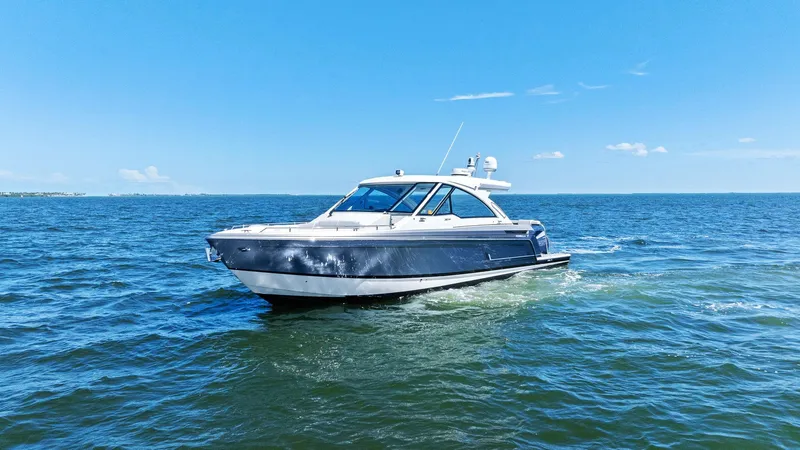 Slide: The Image of 2023 Formula 380 Super Sport Crossover OB cruising on open water under clear blue sky. - 3
